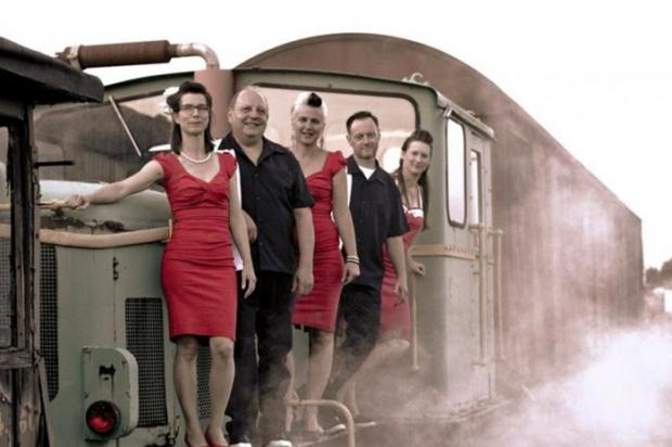 People standing on the front of a train in matching clothes