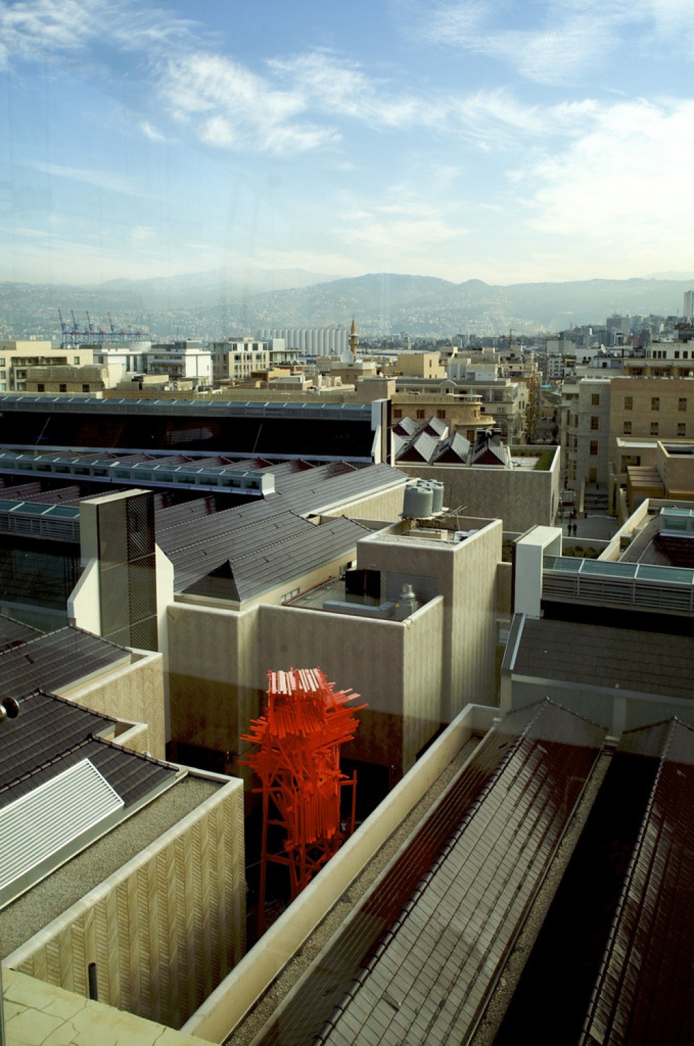 Red wood sculpture in the middle of buildings